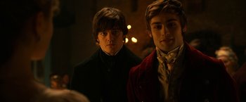 Movie still from “Pride and Prejudice and Zombies” (2016), directed by Burr Steers – Two young men standing next to each other in a dark room; Close Up shot, Over the shoulder angle