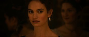 Movie still from “Pride and Prejudice and Zombies” (2016), directed by Burr Steers – A beautiful woman with long dark brown hair wearing gold earrings; Close Up shot, Over the shoulder angle