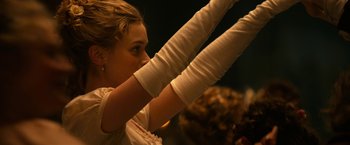 Movie still from “Pride and Prejudice and Zombies” (2016), directed by Burr Steers – A woman wearing white gloves is holding her arms up; Close Up shot, Low angle