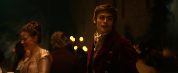 Movie still from “Pride and Prejudice and Zombies” (2016), directed by Burr Steers – A man in a red jacket standing in a dark room; Close Up shot, Over the shoulder angle