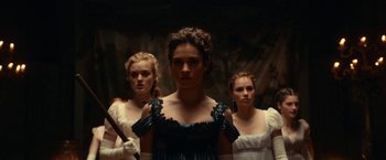 Movie still from “Pride and Prejudice and Zombies” (2016), directed by Burr Steers – A group of women standing next to each other in a dark room; Medium shot, Low angle