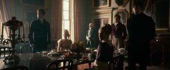 Movie still from “Pride and Prejudice and Zombies” (2016), directed by Burr Steers – A group of people sitting around a table with plates of food on top of it; Wide shot, Over the shoulder angle