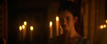 Movie still from “Pride and Prejudice and Zombies” (2016), directed by Burr Steers – A beautiful young lady standing in front of candles in a room; Close Up shot, Over the shoulder angle