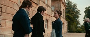Movie still from “Pride and Prejudice and Zombies” (2016), directed by Burr Steers – A group of people standing next to each other near a building; Medium shot, Over the shoulder angle