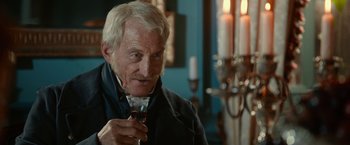 Movie still from “Pride and Prejudice and Zombies” (2016), directed by Burr Steers – An older man holding a wine glass in his hand; Close Up shot, Over the shoulder angle