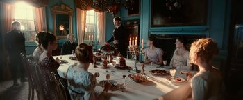 Movie still from “Pride and Prejudice and Zombies” (2016), directed by Burr Steers – A group of people sitting around a table with food on top of it; Wide shot, High angle
