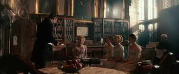 Movie still from “Pride and Prejudice and Zombies” (2016), directed by Burr Steers – A group of people sitting in a room with books; Wide shot, Over the shoulder angle