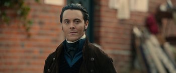 Movie still from “Pride and Prejudice and Zombies” (2016), directed by Burr Steers – A person wearing a suit and tie; Close Up shot, Over the shoulder angle