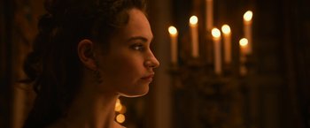 Movie still from “Pride and Prejudice and Zombies” (2016), directed by Burr Steers – A beautiful woman looking to the side in front of candles; Close Up shot, Over the shoulder angle
