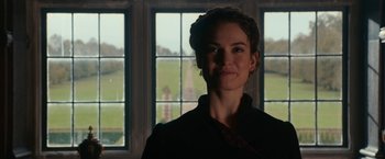 Movie still from “Pride and Prejudice and Zombies” (2016), directed by Burr Steers – A woman standing in front of a window; Close Up shot, Over the shoulder angle