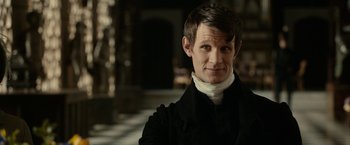Movie still from “Pride and Prejudice and Zombies” (2016), directed by Burr Steers – A man in a black coat and a white neck tie; Close Up shot, Over the shoulder angle