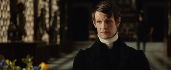 Movie still from “Pride and Prejudice and Zombies” (2016), directed by Burr Steers – A man wearing a black suit and a white shirt; Close Up shot, Over the shoulder angle