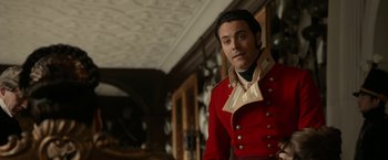 Movie still from “Pride and Prejudice and Zombies” (2016), directed by Burr Steers – A man in a red coat standing next to a wall; Medium shot, Over the shoulder angle