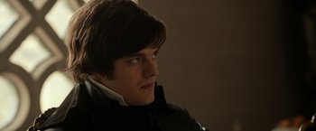 Movie still from “Pride and Prejudice and Zombies” (2016), directed by Burr Steers – A young man with long brown hair looking to his left; Close Up shot, Over the shoulder angle