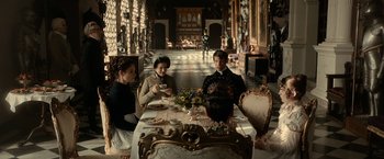 Movie still from “Pride and Prejudice and Zombies” (2016), directed by Burr Steers – A group of people sitting at a table with cups; Wide shot, High angle