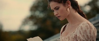 Movie still from “Pride and Prejudice and Zombies” (2016), directed by Burr Steers – A young woman is reading a book outside; Close Up shot, Over the shoulder angle