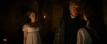 Movie still from “Pride and Prejudice and Zombies” (2016), directed by Burr Steers – A man and a woman standing next to each other in a room; Medium shot, Over the shoulder angle