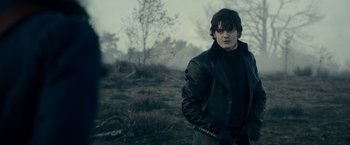 Movie still from “Pride and Prejudice and Zombies” (2016), directed by Burr Steers – A man in a black jacket standing in a field; Medium shot, Over the shoulder angle