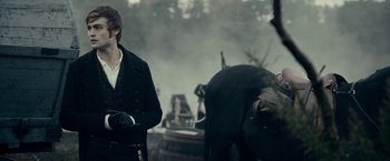 Movie still from “Pride and Prejudice and Zombies” (2016), directed by Burr Steers – A man standing next to a boat on a river; Medium shot, Over the shoulder angle