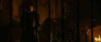 Movie still from “Pride and Prejudice and Zombies” (2016), directed by Burr Steers – A man standing in a dark room holding an umbrella; Medium shot, Over the shoulder angle