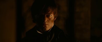 Movie still from “Pride and Prejudice and Zombies” (2016), directed by Burr Steers – A young man in a black shirt and a black tie; Close Up shot, Over the shoulder angle