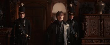 Movie still from “Pride and Prejudice and Zombies” (2016), directed by Burr Steers – A man in a black jacket standing next to another man in a black jacket; Medium shot, Over the shoulder angle