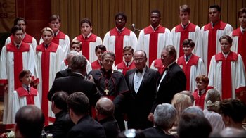 Movie still from “Primal Fear” (1996), directed by Gregory Hoblit – A group of men in suits standing next to each other in a room; Medium shot, High angle