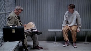 Movie still from “Primal Fear” (1996), directed by Gregory Hoblit – Two people sitting on a bench and one is reading a newspaper; Wide shot, Over the shoulder angle