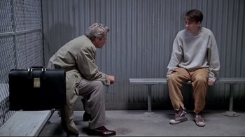 Movie still from “Primal Fear” (1996), directed by Gregory Hoblit – Two people sitting on a bench in a room; Wide shot, Over the shoulder angle