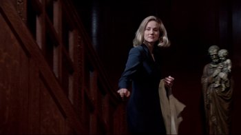 Movie still from “Primal Fear” (1996), directed by Gregory Hoblit – A woman walking up a set of stairs holding a bag; Medium shot, Low angle