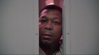 Movie still from “Primal Fear” (1996), directed by Gregory Hoblit – A person looking through a door; Close Up shot, Low angle