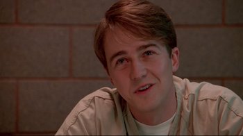 Movie still from “Primal Fear” (1996), directed by Gregory Hoblit – A young man sitting in front of a brick wall; Close Up shot, Low angle