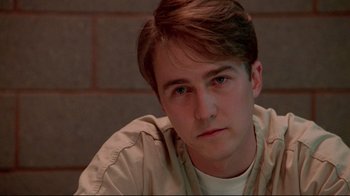 Movie still from “Primal Fear” (1996), directed by Gregory Hoblit – A young man sitting in front of a brick wall; Close Up shot, Low angle