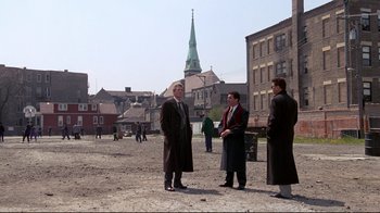 Movie still from “Primal Fear” (1996), directed by Gregory Hoblit – A group of men standing on a dirt field; Wide shot, High angle