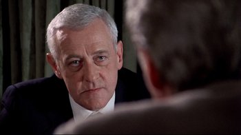 Movie still from “Primal Fear” (1996), directed by Gregory Hoblit – An older man wearing a suit looking at a mirror; Close Up shot, Over the shoulder angle