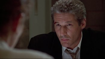 Movie still from “Primal Fear” (1996), directed by Gregory Hoblit – A person wearing a suit and tie; Close Up shot, Over the shoulder angle