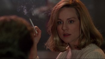 Movie still from “Primal Fear” (1996), directed by Gregory Hoblit – A woman smoking a cigarette while looking at the camera; Close Up shot, Over the shoulder angle