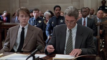 Movie still from “Primal Fear” (1996), directed by Gregory Hoblit – Two men are sitting in a court room; Medium shot, Over the shoulder angle