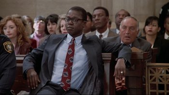 Movie still from “Primal Fear” (1996), directed by Gregory Hoblit – A group of people sitting in a room; Medium shot, Low angle