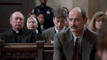 Movie still from “Primal Fear” (1996), directed by Gregory Hoblit – A group of people sitting in a court room; Medium shot, Low angle