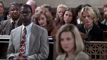 Movie still from “Primal Fear” (1996), directed by Gregory Hoblit – A group of people sitting in front of each other in a church; Medium shot, Over the shoulder angle