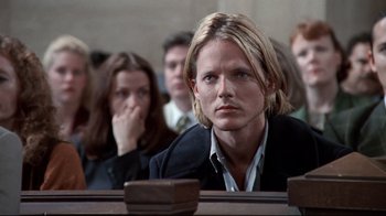 Movie still from “Primal Fear” (1996), directed by Gregory Hoblit – A man sitting in front of a group of people in a courtroom; Close Up shot, Low angle
