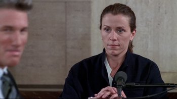 Movie still from “Primal Fear” (1996), directed by Gregory Hoblit – A woman sitting in front of microphones in a room; Close Up shot, Low angle
