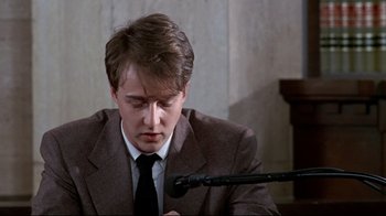 Movie still from “Primal Fear” (1996), directed by Gregory Hoblit – A man in a suit and tie writing on a piece of paper; Close Up shot, High angle