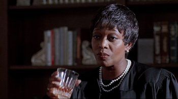 Movie still from “Primal Fear” (1996), directed by Gregory Hoblit – A woman holding a glass of water in her hand; Close Up shot, Over the shoulder angle