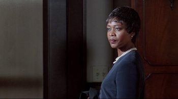 Movie still from “Primal Fear” (1996), directed by Gregory Hoblit – A woman with short hair wearing a blue jacket; Close Up shot, Over the shoulder angle