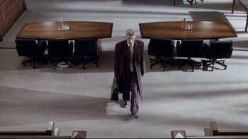 Movie still from “Primal Fear” (1996), directed by Gregory Hoblit – A man in a suit and tie walking through a room; Wide shot, High angle