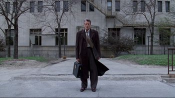Movie still from “Primal Fear” (1996), directed by Gregory Hoblit – A man standing in front of a building holding a briefcase; Wide shot, Low angle
