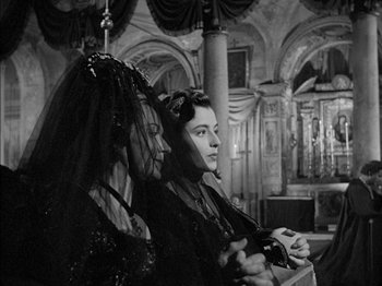 Movie still from “Prince of Foxes” (1949), directed by Henry King – Two women in a room holding a game controller; Medium shot, Over the shoulder angle