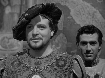 Movie still from “Prince of Foxes” (1949), directed by Henry King – A man with a beard wearing a hat and a suit; Close Up shot, Over the shoulder angle